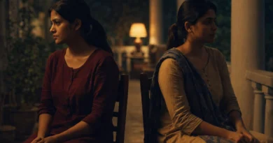 Two Indian sisters sitting apart on a veranda at night in silence, warm light showing emotional distance