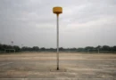 Empty korfball post on a quiet outdoor ground under an overcast sky in India