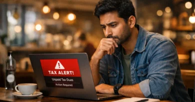 Young Indian professional looking at tax alert notification on laptop in coffee shop
