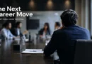 Professional sitting quietly at a conference table while colleagues discuss business strategy
