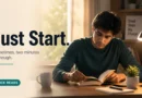 A young professional starts reading a book at a clean desk, illustrating The 2-Minute Rule and the power of taking small first steps.