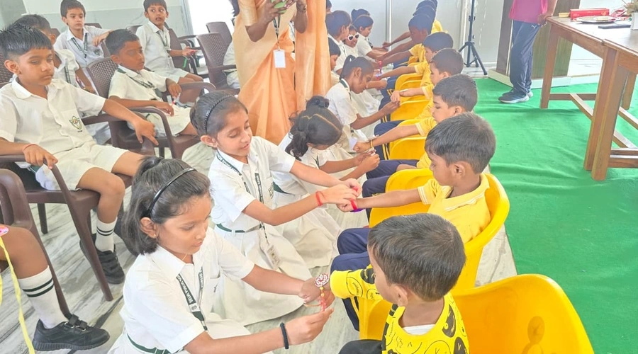 Children tying rakhis during Raksha Bandhan celebration at Bal Grih in Babatpur