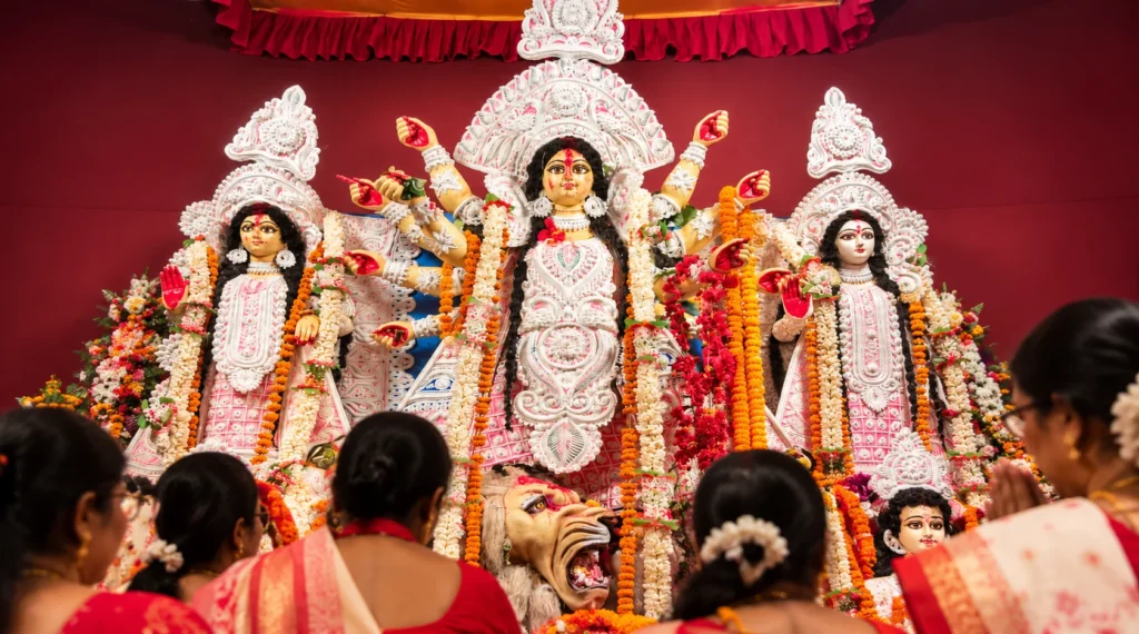 दुर्गा पूजा के दौरान सजी माँ दुर्गा की प्रतिमा और सामने उपस्थित श्रद्धालु