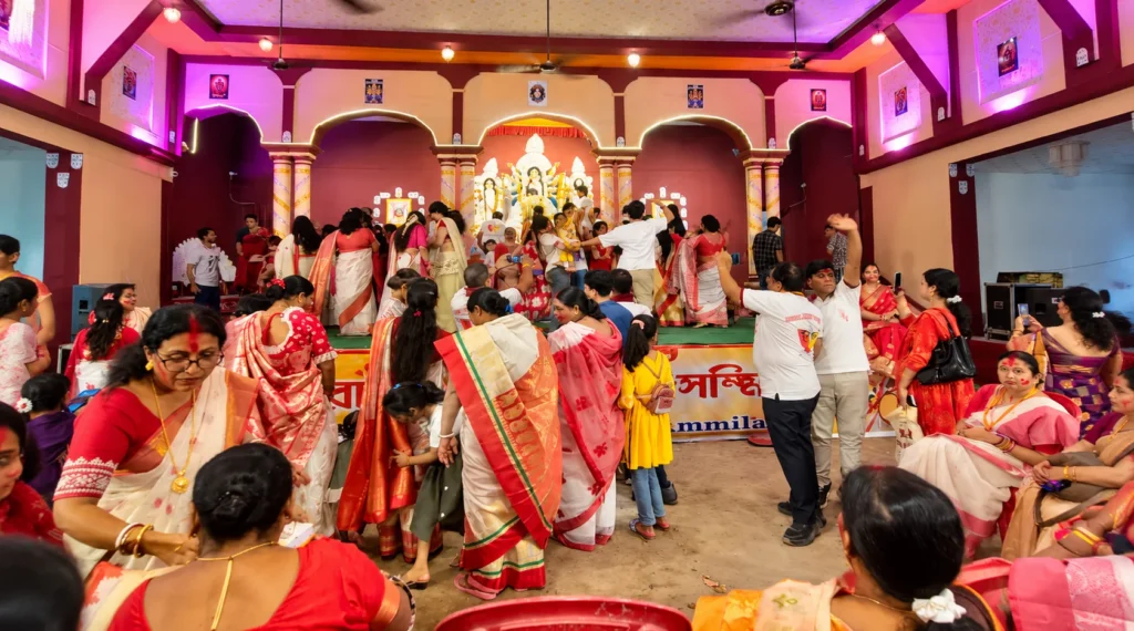 दुर्गा पूजा के दौरान सजे पंडाल में उत्सव मनाते लोग
